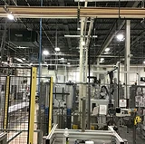 High-ceiling industrial facility with overhead structures and ducts, showing surfaces that require specialized ceiling cleaning.